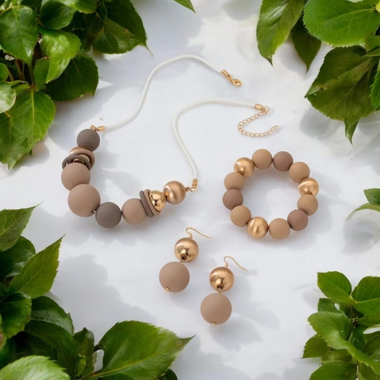 Elegant 3-piece set includes a multi-layer necklace, bracelet, and matching earrings, all crafted with matte acrylic beads. The design combines three harmonious tones — soft beige, deep brown, and radiant gold — creating a warm, earthy palette.