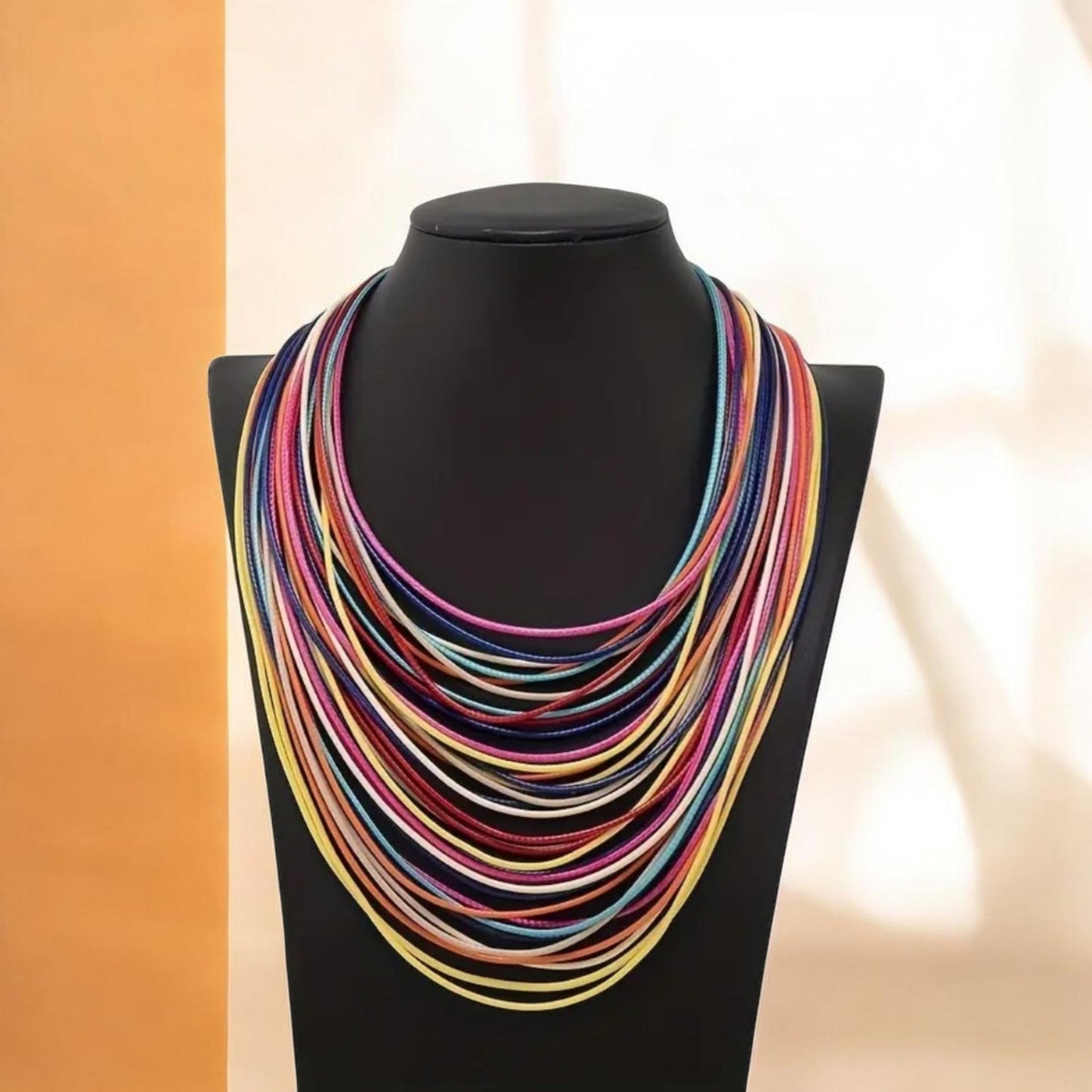 This statement piece embodies bohemian spirit with a bold bib-style design. Handcrafted from durable waxed thread, the necklace features intricate braided rope layers that create texture and depth. Its vibrant mix of colors adds playful energy, while the retro-inspired aesthetic makes it a standout accessory.