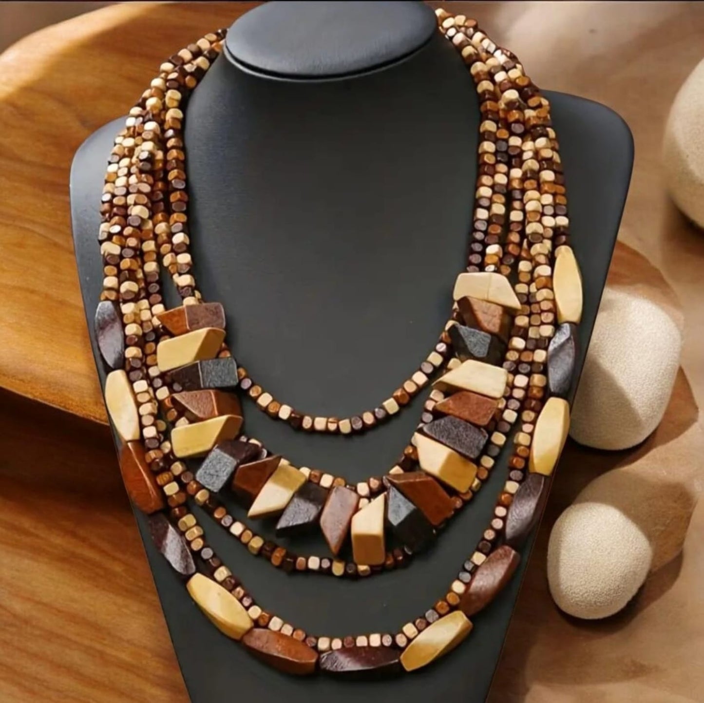This free-spirited necklace embodies bohemian style with its wooden beads arranged in multiple flowing layers. Each strand adds depth and movement, creating a rich, textured look that feels earthy yet artistic.