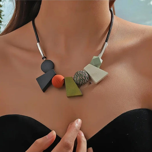 This striking necklace embodies a bohemian spirit with a tribal edge. Crafted in bold geometric shapes, it features earthy green tones that evoke nature and balance. The design blends angular symmetry with organic charm, creating a statement piece that feels both grounded and free-spirited.