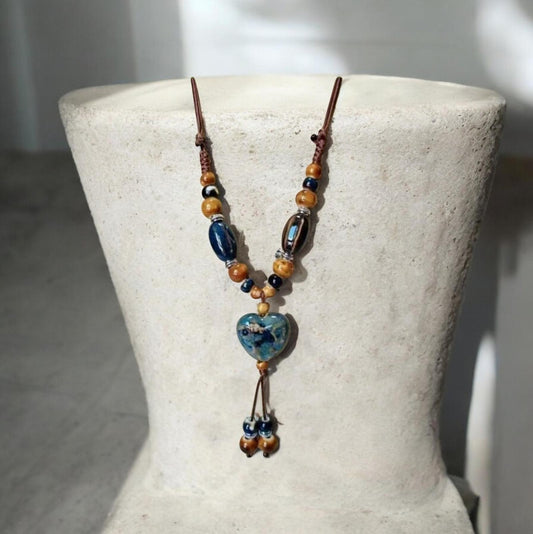 This ceramic bead necklace is designed to be both charming and distinctive, making it a perfect centerpiece for your collection. Strung along a smooth cord, the necklace features polished ceramic beads that create a balanced rhythm of texture and shine.