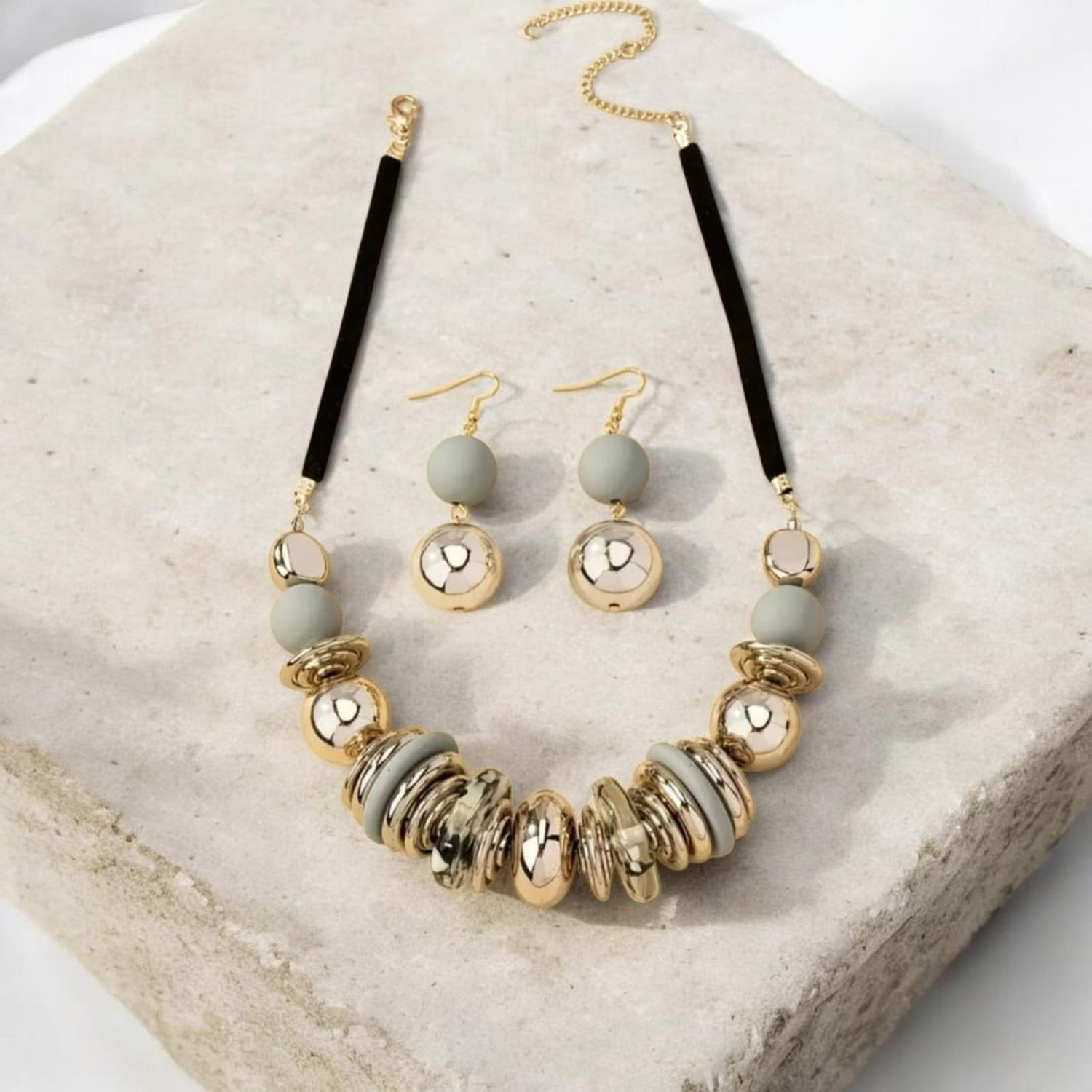 This chic 2-piece set captures vintage charm with a bold retro design. The necklace features alternating acrylic grey beads and shimmering gold beads, arranged in a balanced composition that radiates timeless elegance.