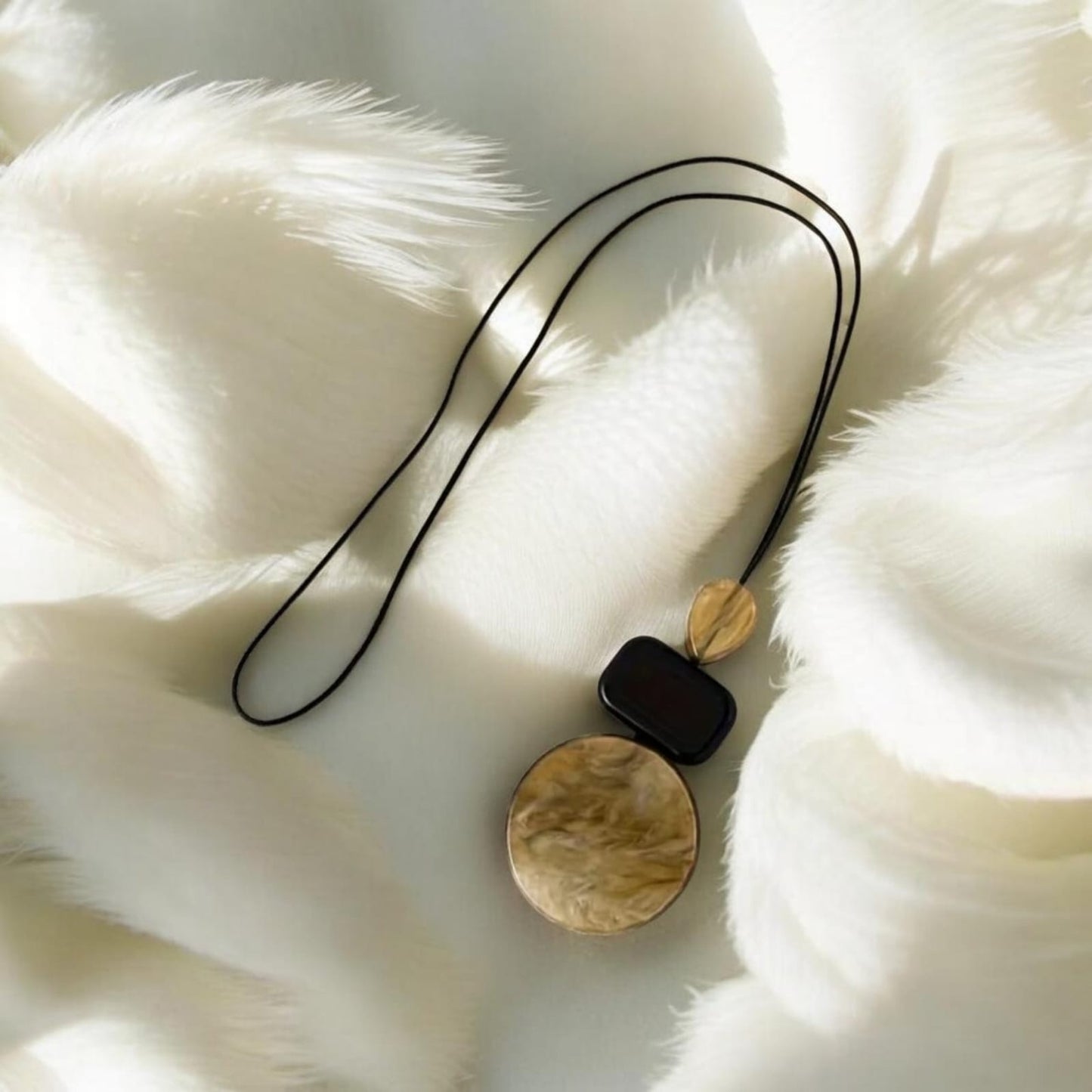 This refined piece showcases handmade craftsmanship with a unique resin pendant tied onto a durable cord necklace. The harmonious brown tones evoke natural beauty, symbolizing balance and earth-inspired elegance.