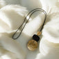 This refined piece showcases handmade craftsmanship with a unique resin pendant tied onto a durable cord necklace. The harmonious brown tones evoke natural beauty, symbolizing balance and earth-inspired elegance.