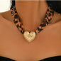 This bold and stylish necklace features a leopard print ribbon that exudes vintage charm and playful sophistication. At its center hangs a gold-plated hammered heart pendant, its textured surface catching the light with artisanal allure.