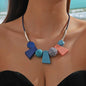 This striking necklace embodies a bohemian spirit with a tribal edge. Crafted in bold geometric shapes, it features earthy blue tones that evoke nature and balance. The design blends angular symmetry with organic charm, creating a statement piece that feels both grounded and free-spirited.