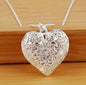 This elegant piece features a finely crafted sterling silver heart pendant delicately engraved with subtle detailing that adds depth and sentiment. Suspended from a sleek snake chain, the design balances modern sophistication with timeless romance