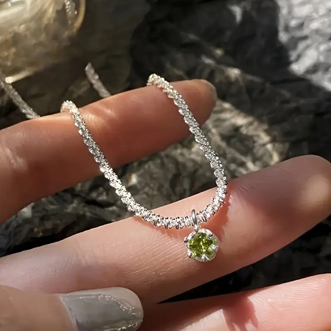 This versatile necklace features a shimmering silver-plated chain paired with a radiant synthetic green cubic zirconia pendant.