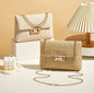 Woven gold lock clasp handbag with gold shoulder strap featured in beige or khaki